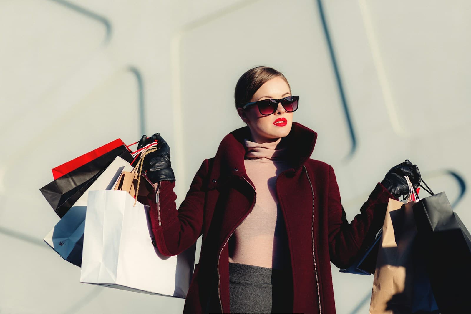 Luxury shopper carrying premium fashion bags in a bright boutique district